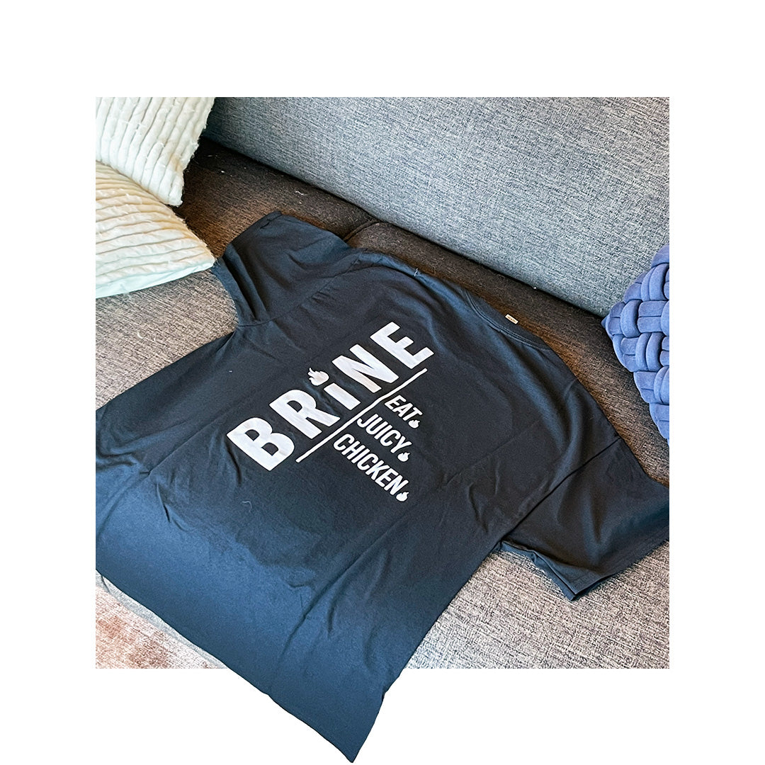 Black Gildan 2000 T-shirt with bold white branding for BRINE, featuring “Eat Juicy Chicken” slogan on the back