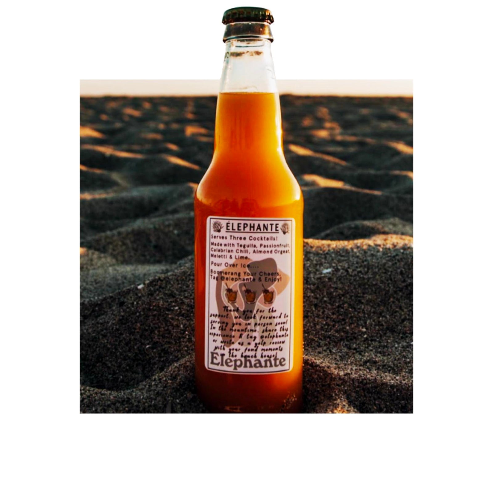 Custom rectangle product label for Elephante cocktail bottle, printed in full color and applied to glass bottle on beach at sunset