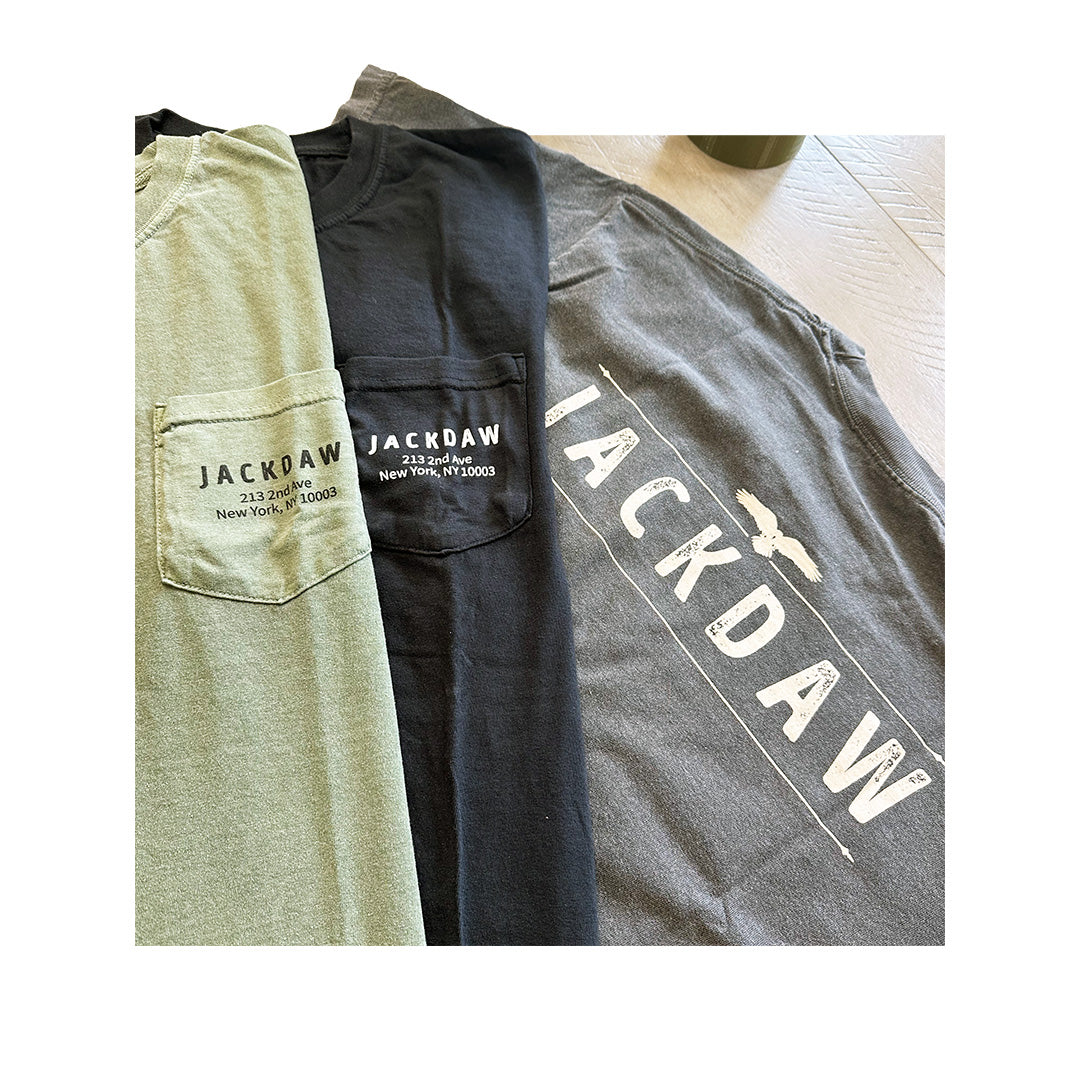 Close-up of Comfort Colors pocket tees with custom logos printed on left chest for Jackdaw NYC