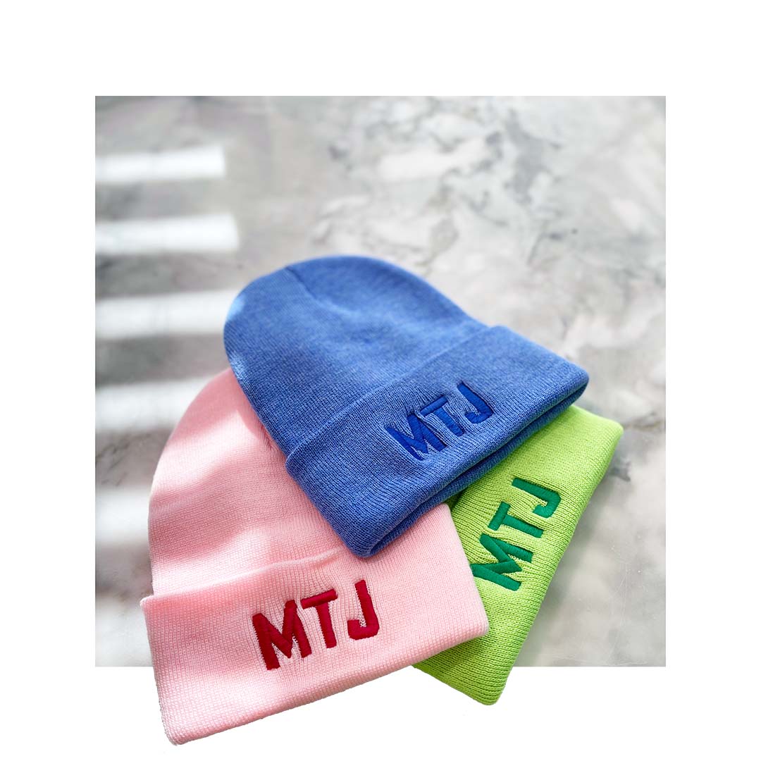 Bright pastel Sportsman SP12 beanies in pink, blue, and green with bold 'MTJ' embroidery