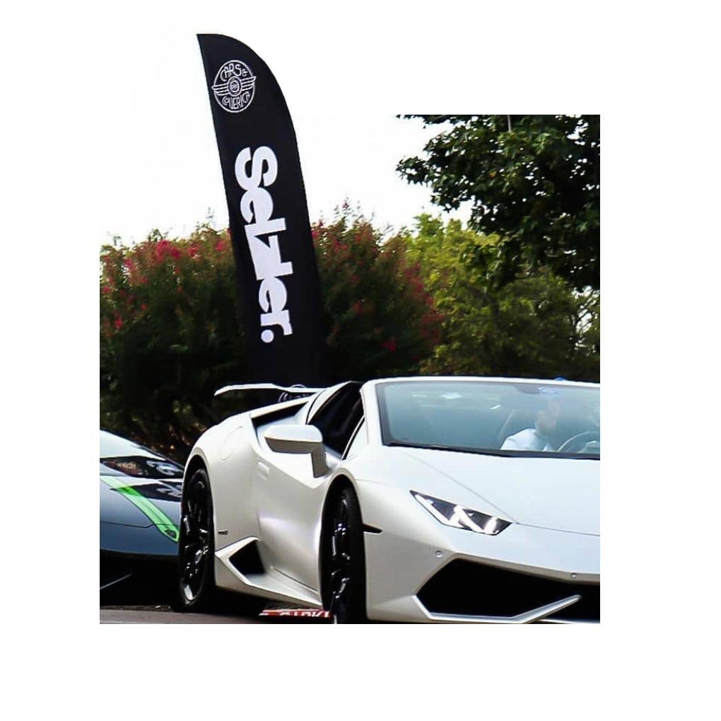 Custom promotional flag on display at a luxury car event, showcasing bold branding