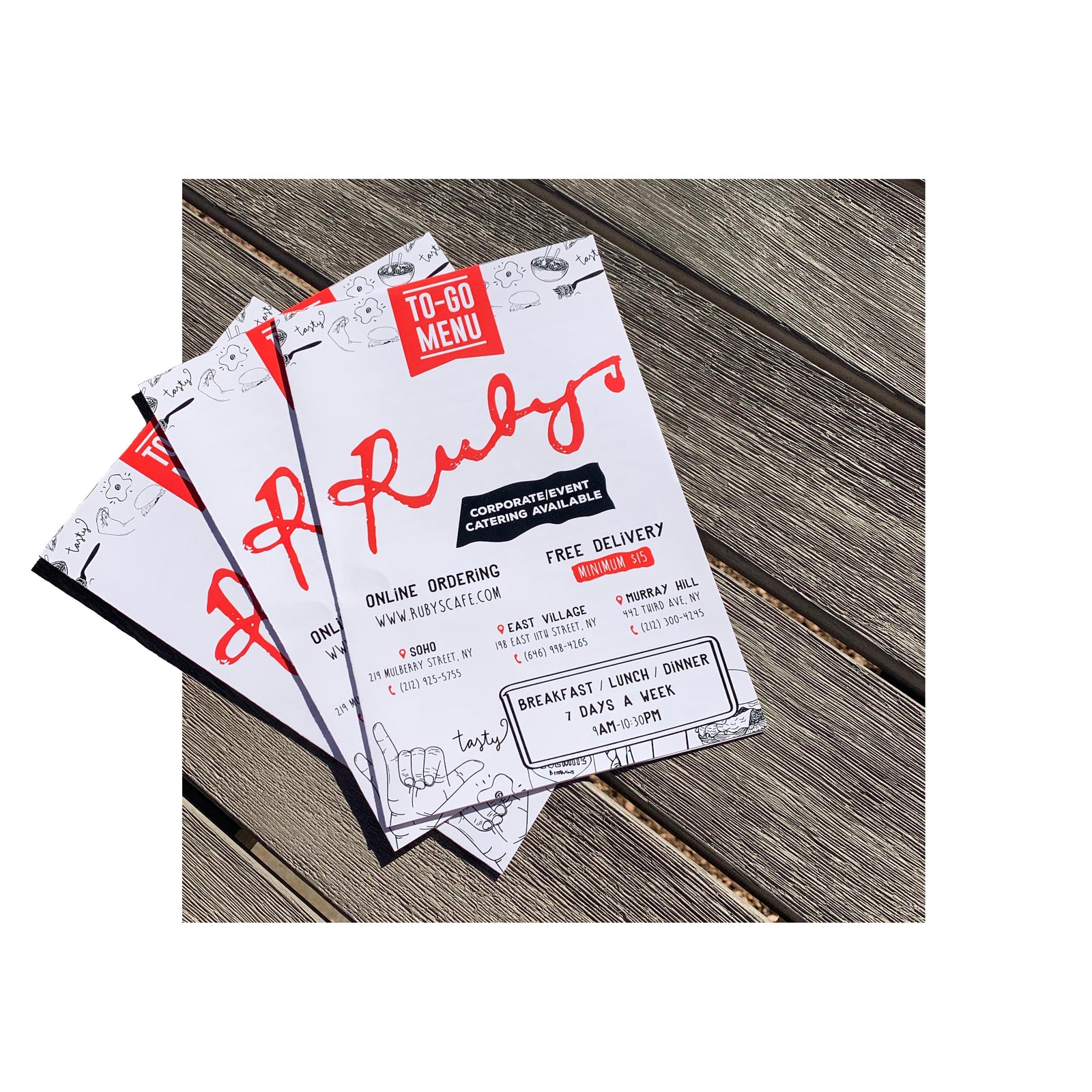 Folded restaurant menus for Ruby’s Café featuring playful illustrations and bold red header