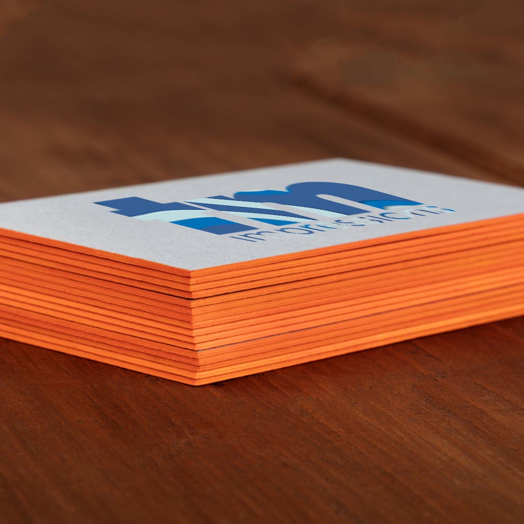 Stack of premium painted edge business cards with bright orange edges and bold blue logo on white front