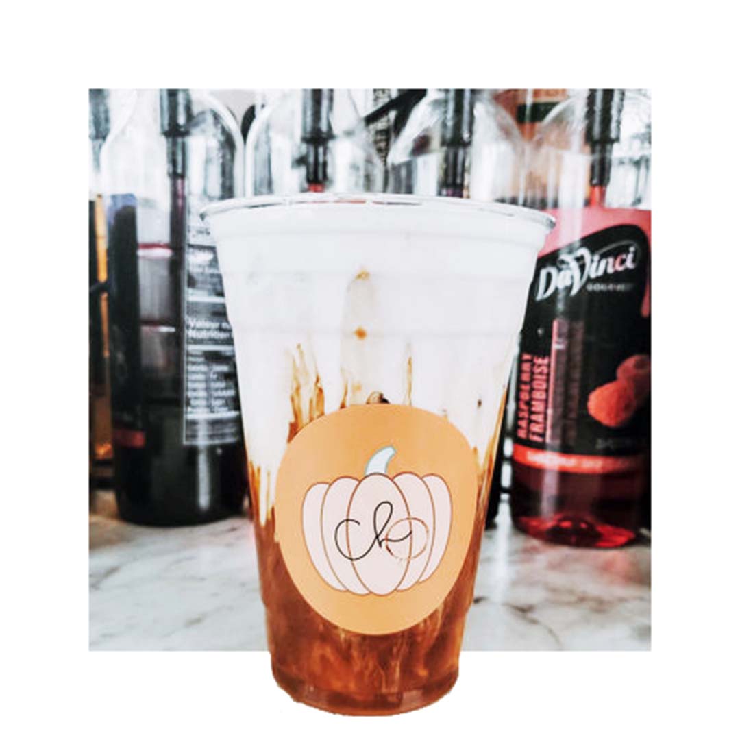 Custom circle label with pumpkin design on iced coffee cup, printed on matte orange background for seasonal fall promotion