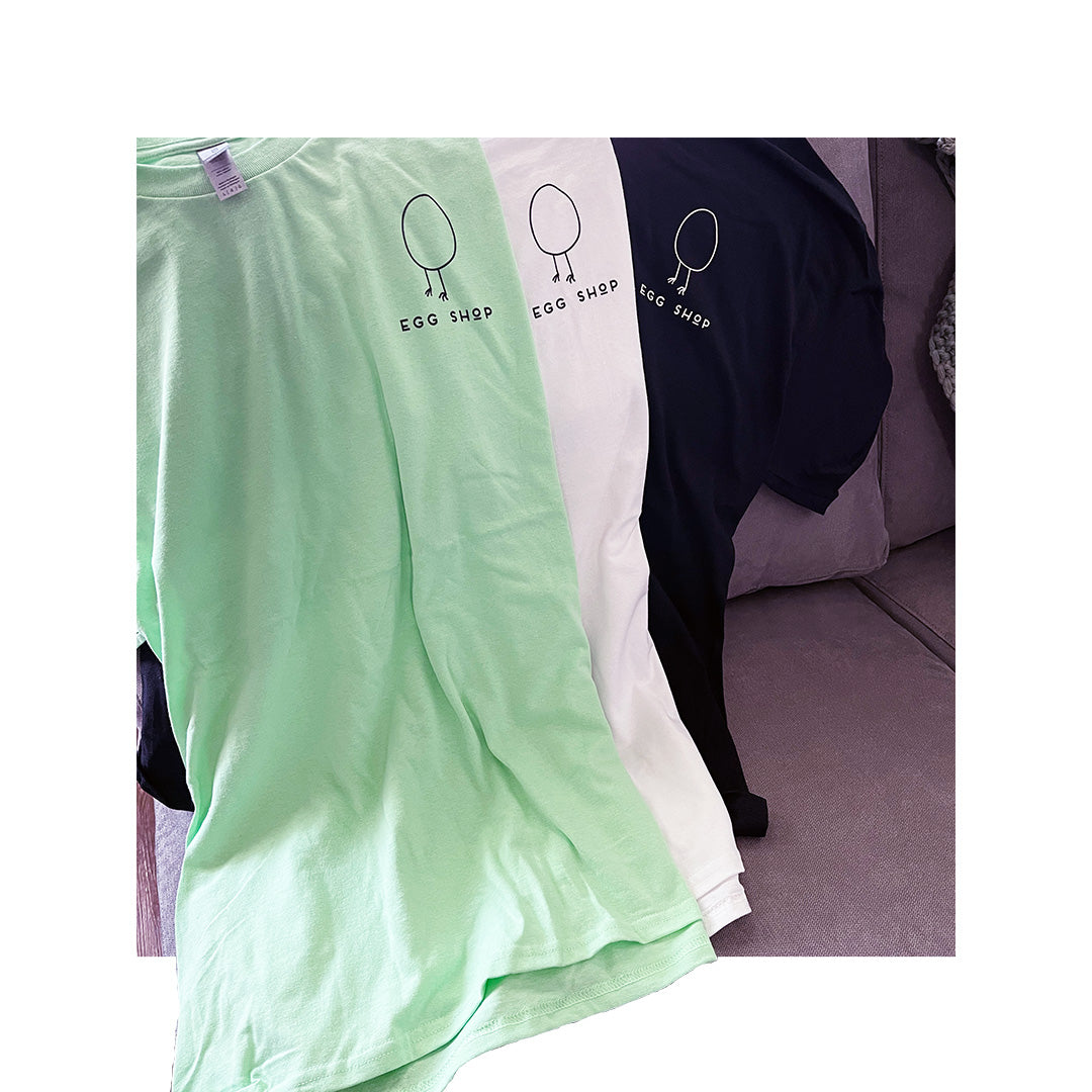 Model wearing a green Gildan 2000 T-shirt with placeholder text "Your Logo Here" for customization preview