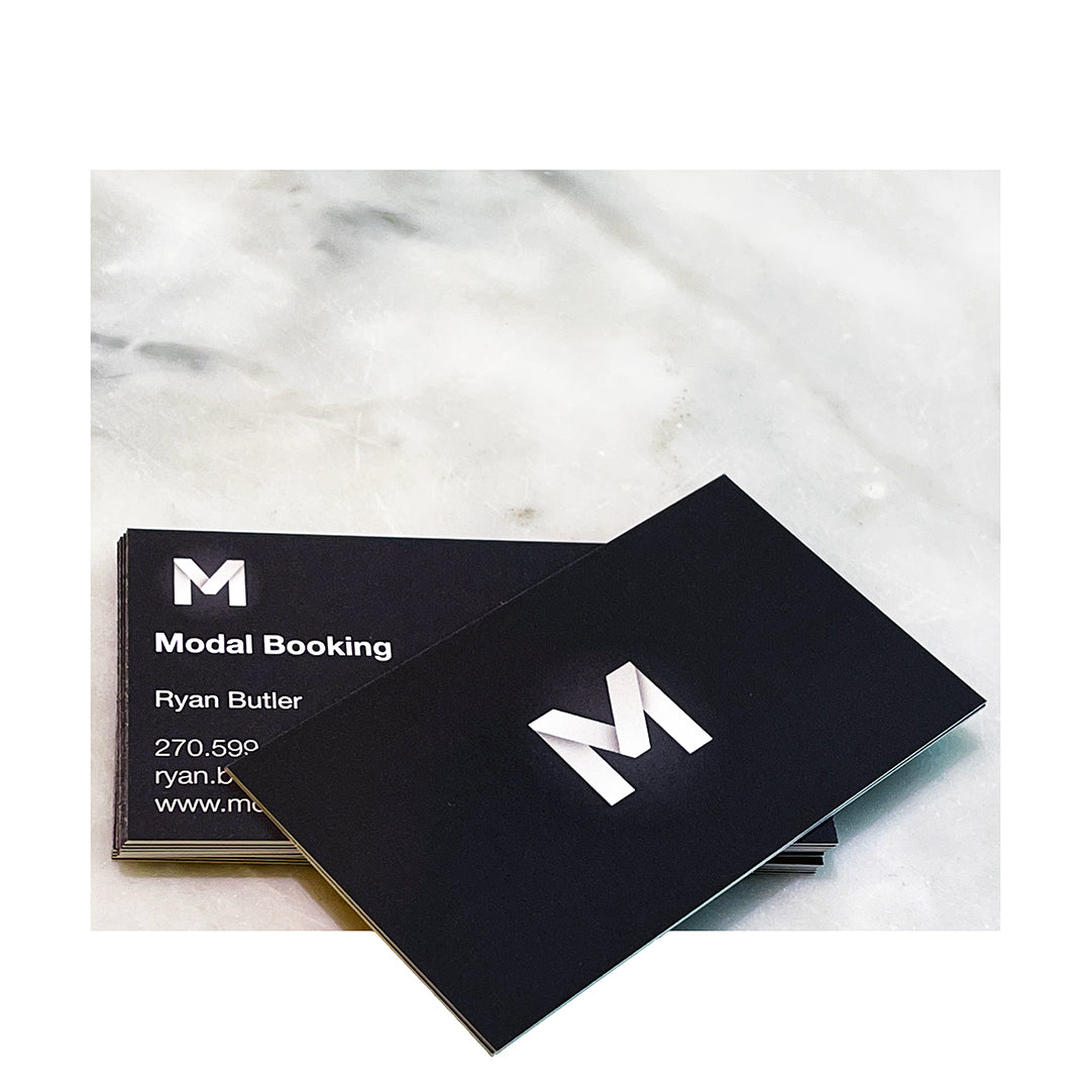 Suede business cards with bold black background and spot gloss 'M' logo for Modal Booking