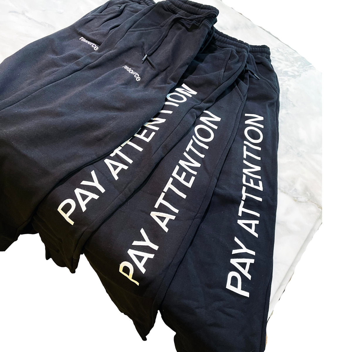 Black Bella Canvas 3727 sweatpants with “PAY ATTENTION” printed vertically down the leg