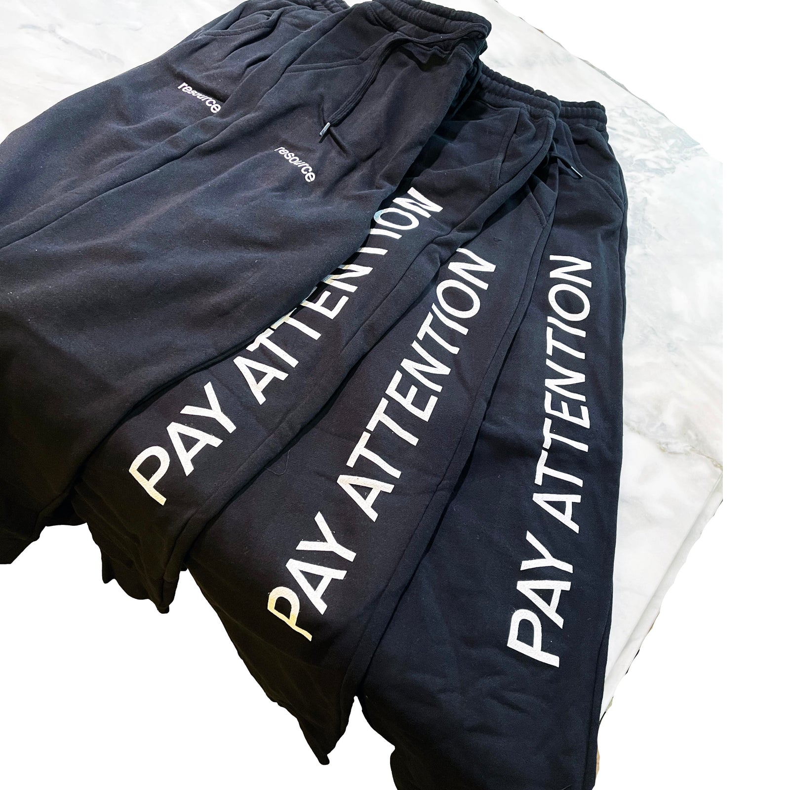 Black Bella Canvas 3727 sweatpants with “PAY ATTENTION” printed vertically down the leg