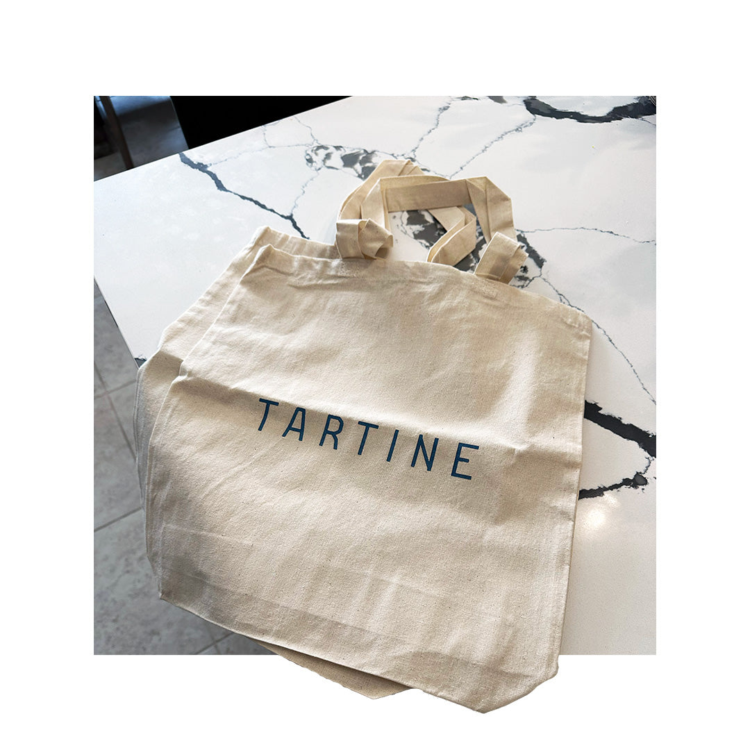 Minimalist canvas tote bag with simple 'TARTINE' print in dark blue ink