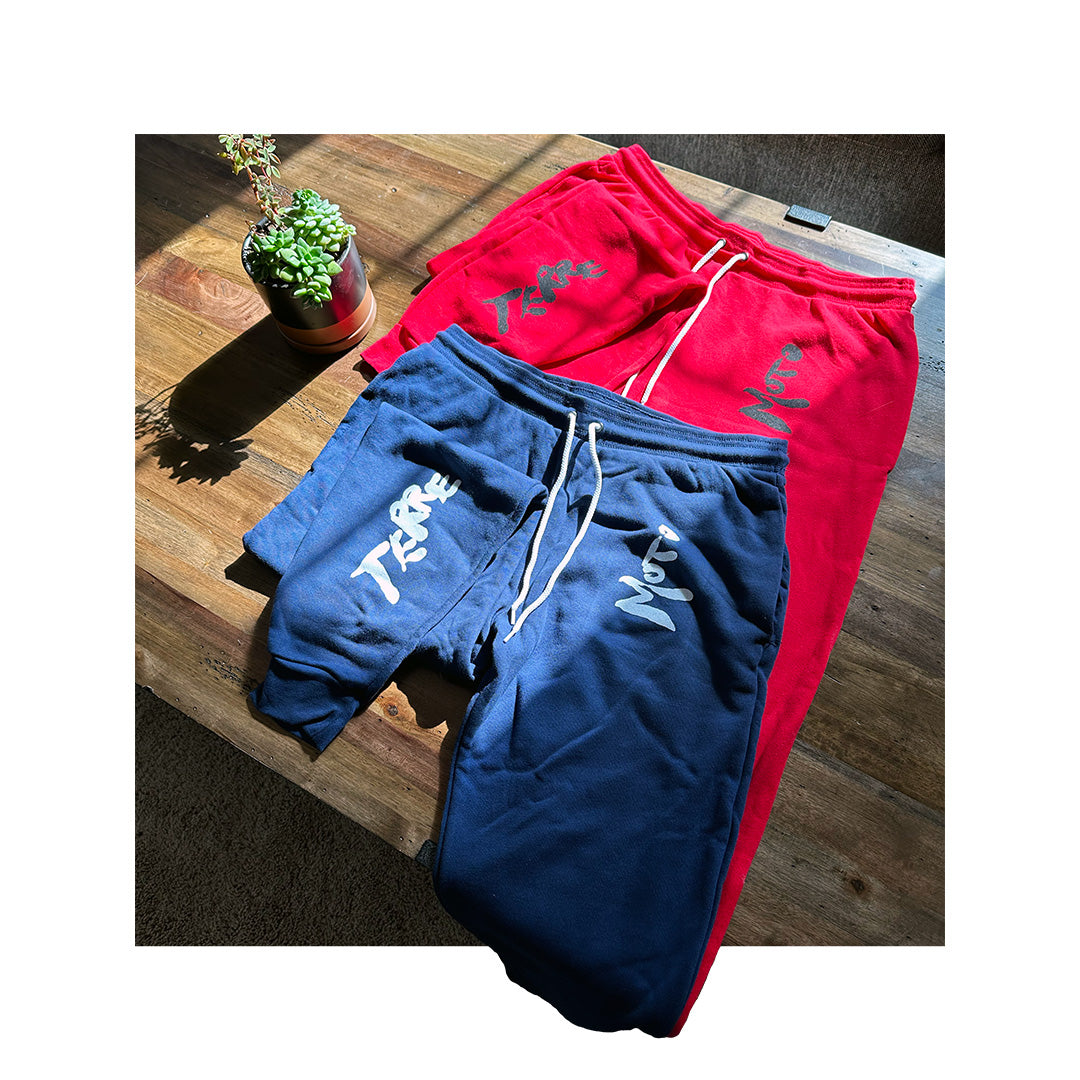 Mockup of Bella Canvas 3727 sweatpants in navy, with placeholder text “Your Logo Here” printed on the front pocket area