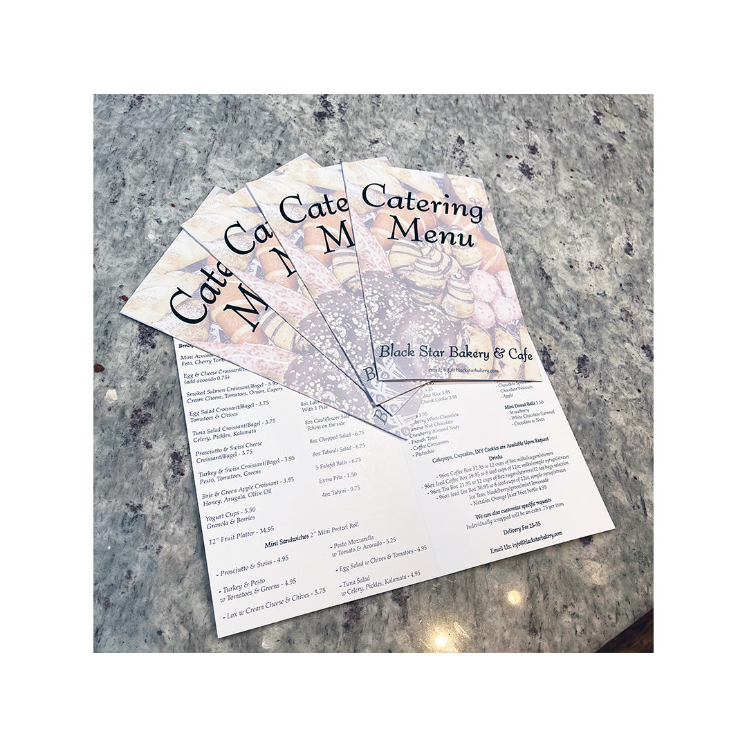 Folded restaurant menus for Ruby’s Café featuring playful illustrations and bold red header