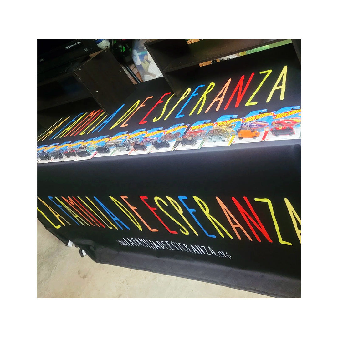 Branded table throw for La Familia de Esperanza, showcasing vibrant multi-color lettering at a nonprofit event.